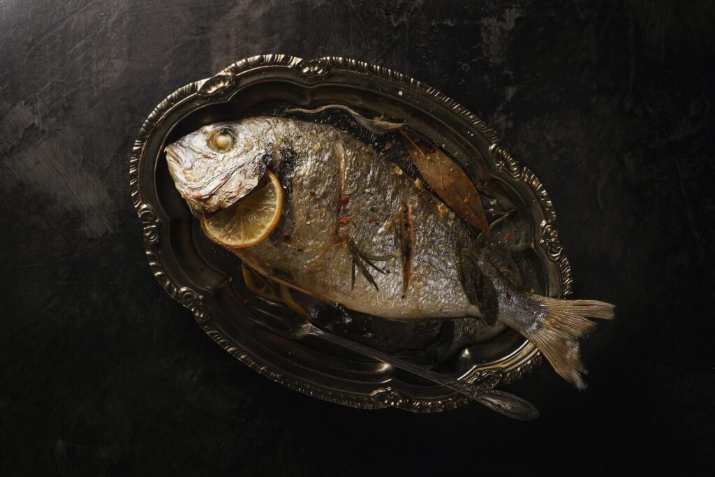 Photo of baked whole fish on silver platter
