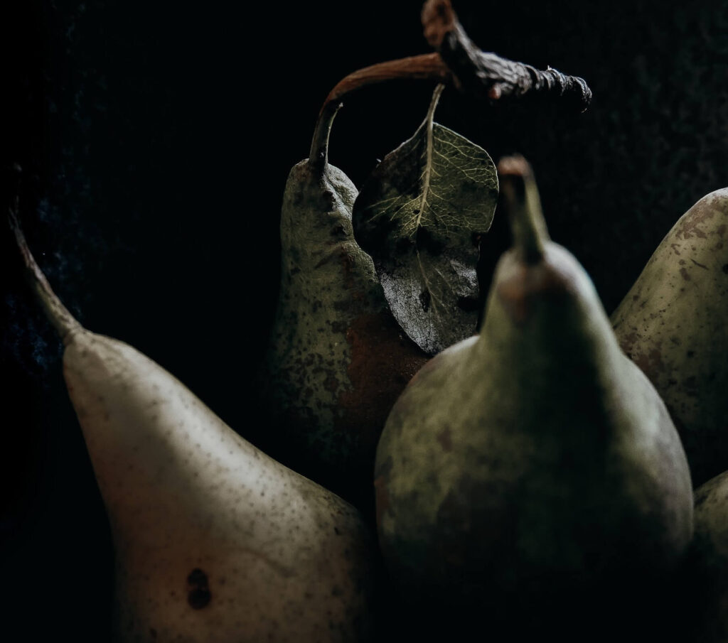 photo of pears and leaves on black background